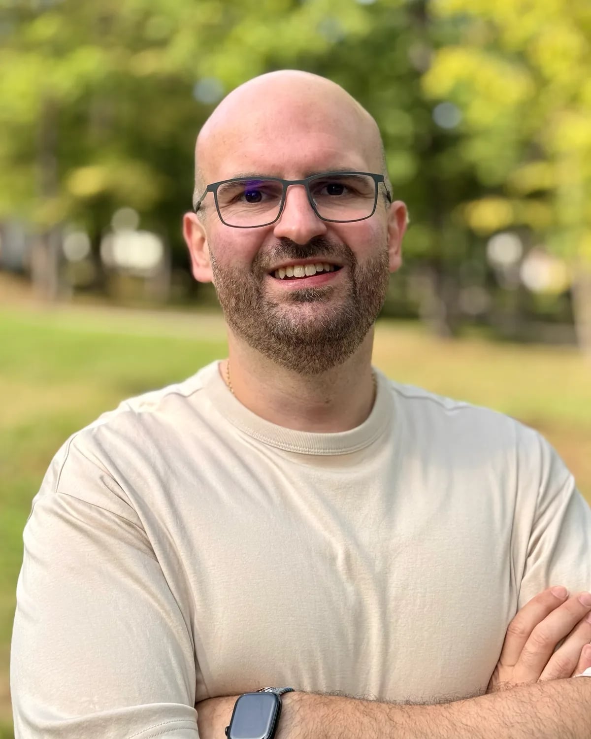 Dominik Frank, Mitgründer und Tech-Lead von CheckerHero, mit Brille und verschränkten Armen im Park