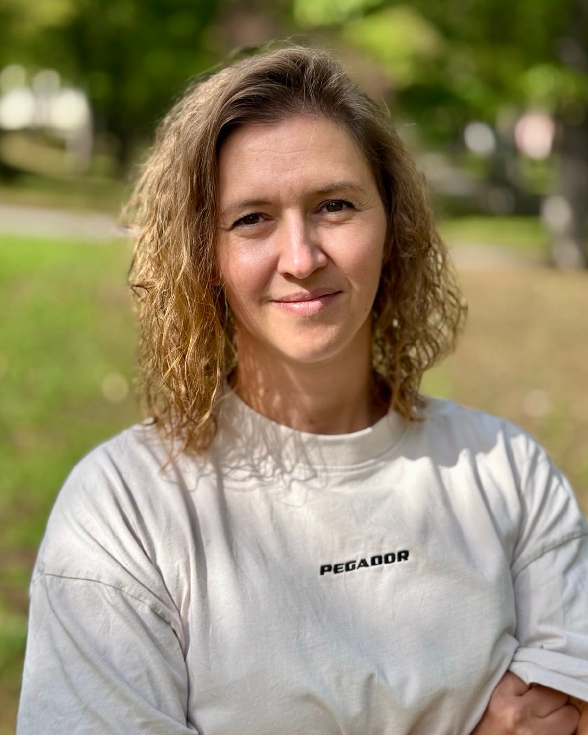 Stefanie Klaue, Mitgründerin von CheckerHero, mit verschränkten Armen lächelnd im Park